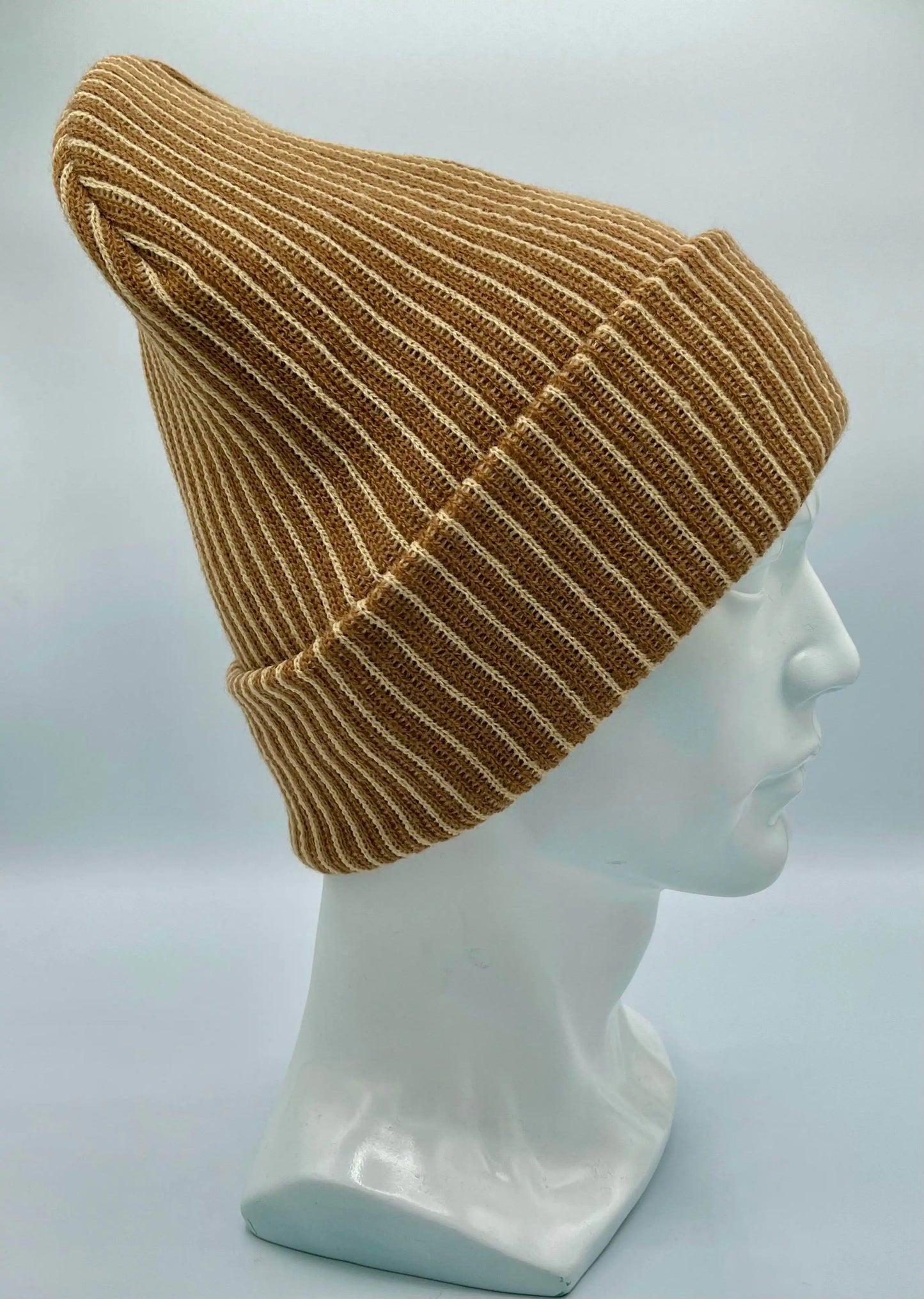Beige and brown ribbed striped beanie with folded cuff, side view, leather logo patch