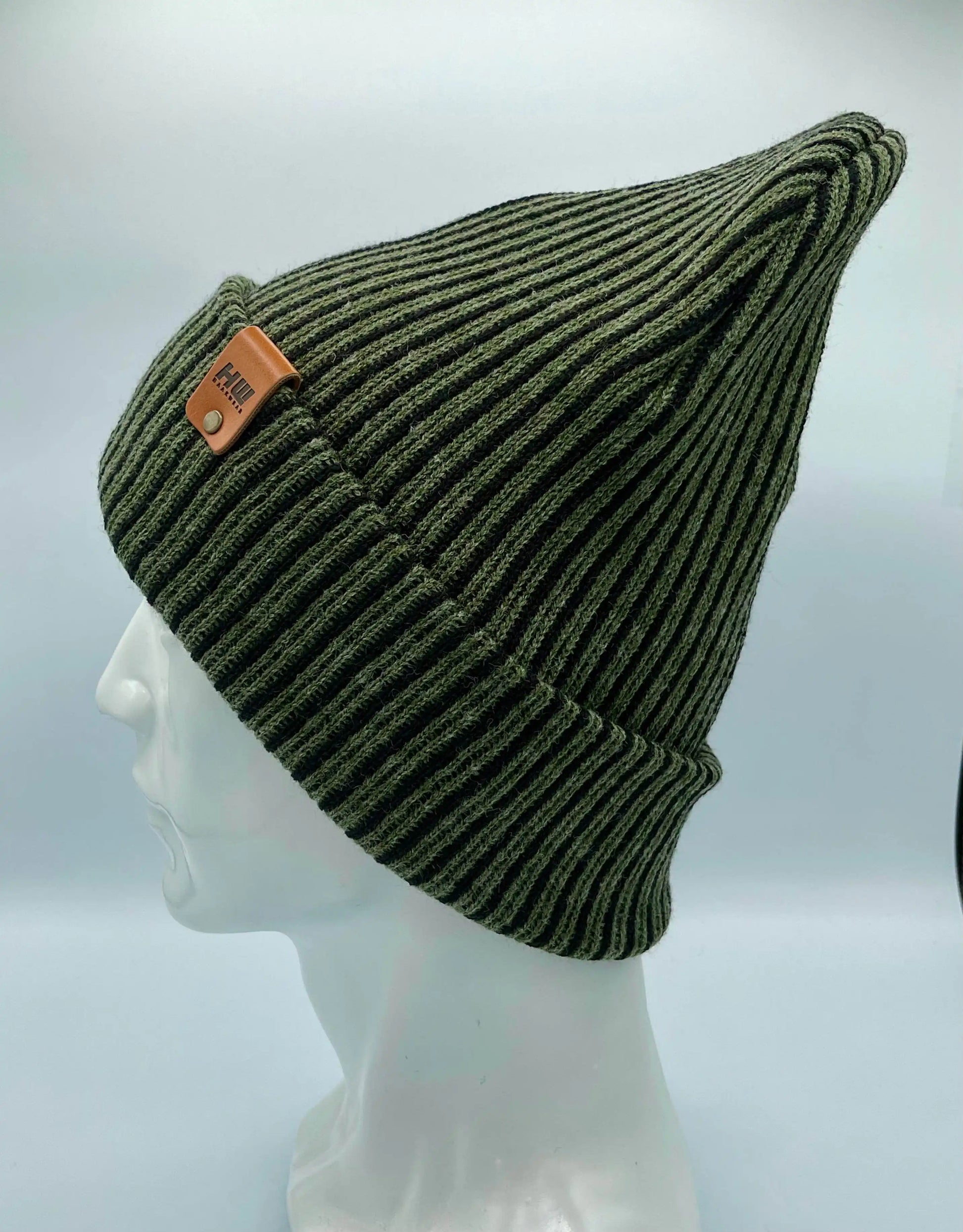 Green ribbed striped beanie with wide cuff and brown leather patch, contrast dark stripes