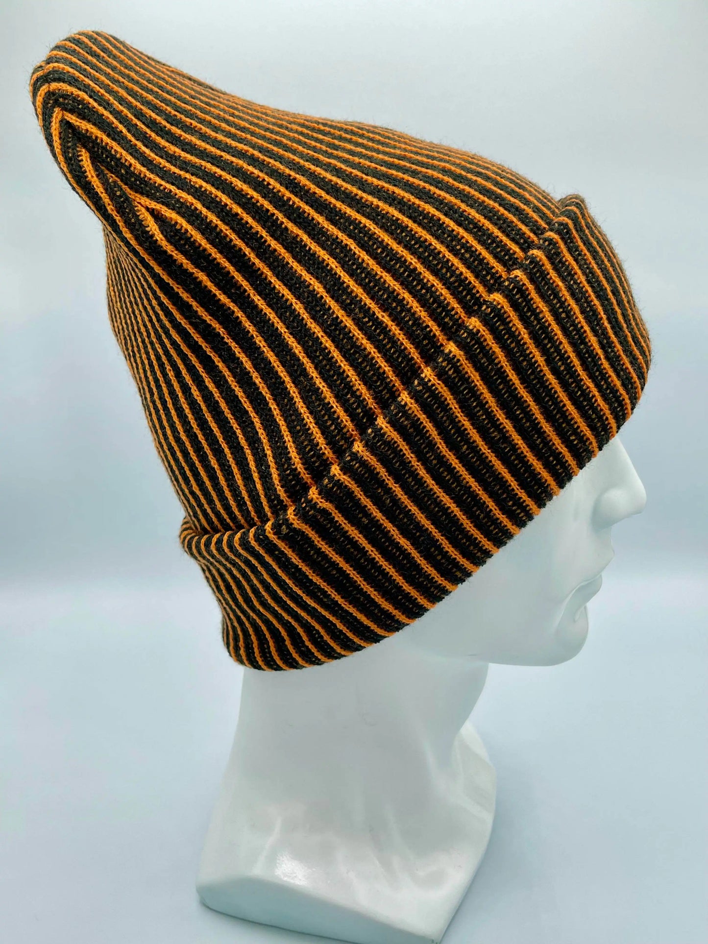 Orange and black striped beanie on mannequin with wide ribbed cuff