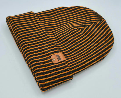 Folded black and orange striped beanie with ribbed cuff and woven patch