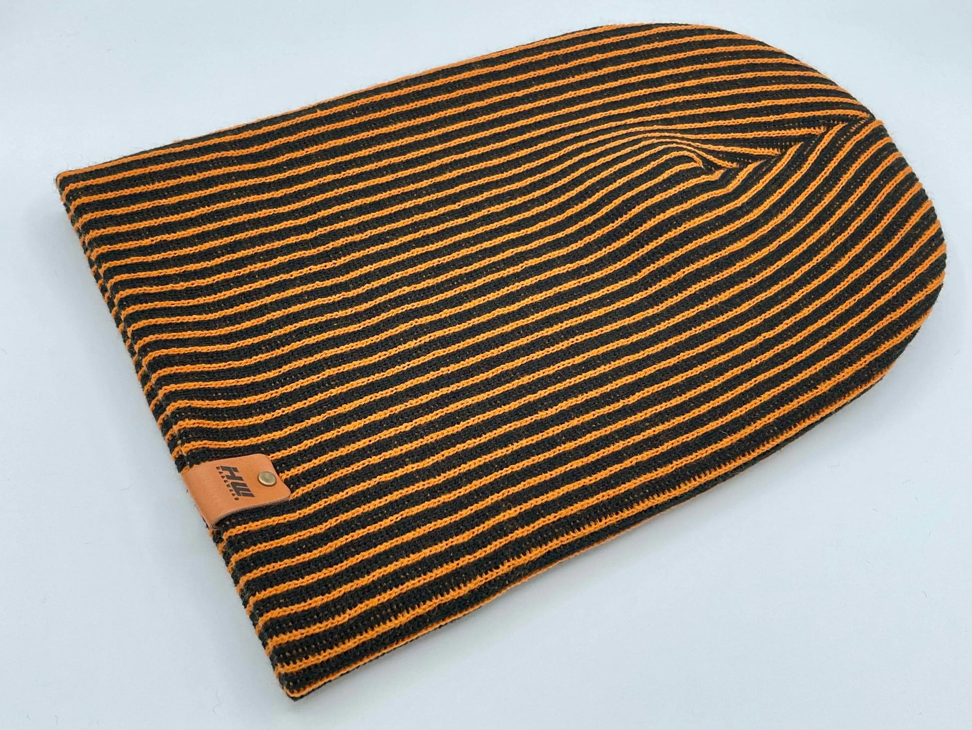Black and orange striped knit beanie with folded cuff and tag patch