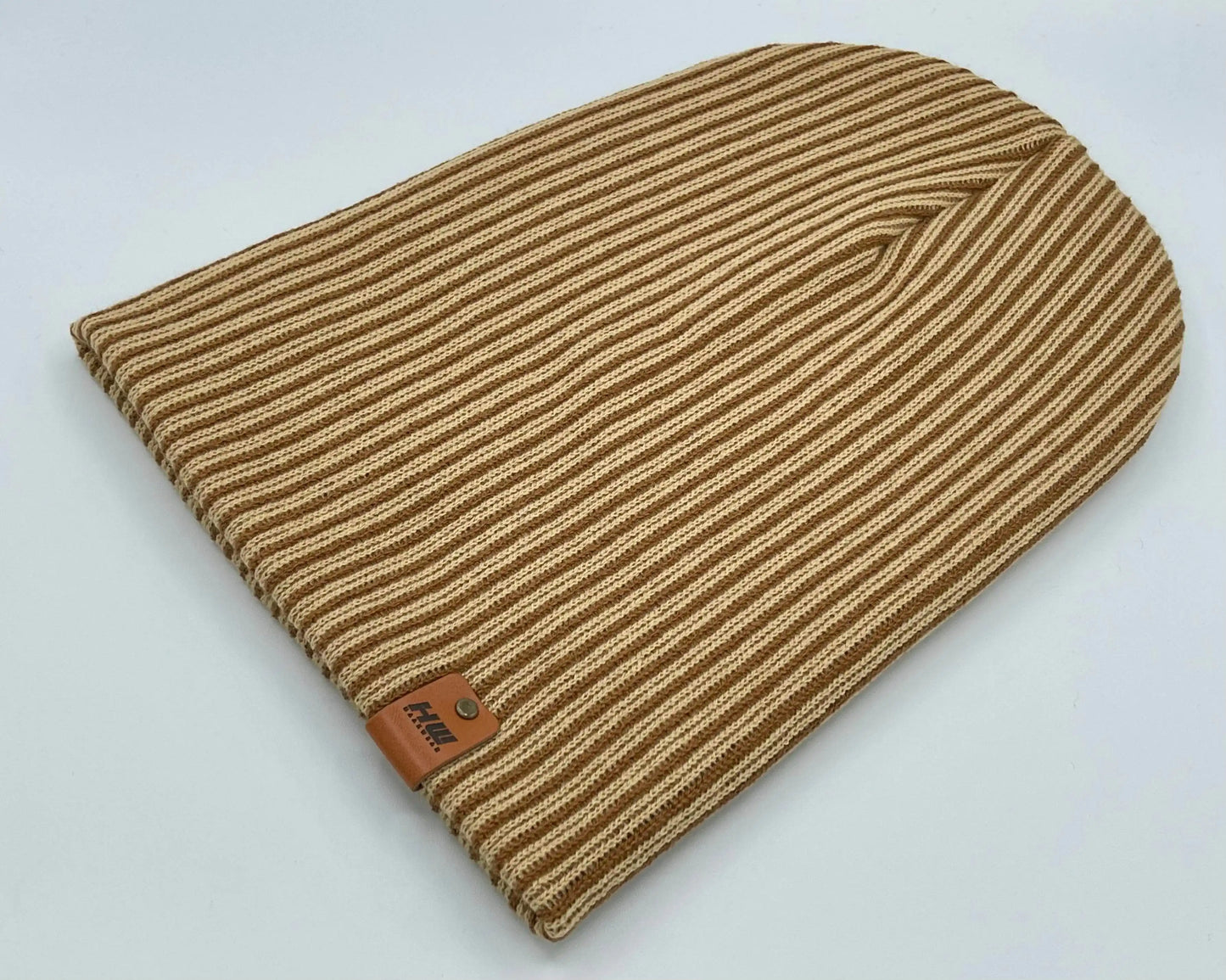 Brown and beige striped ribbed knit beanie with leather logo patch, folded