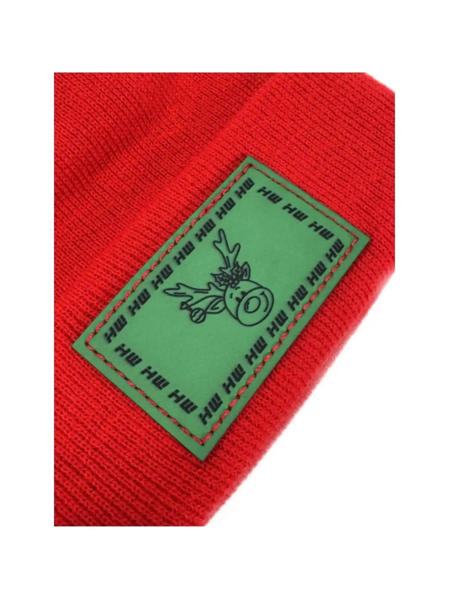 Red knit beanie with green reindeer label patch close-up