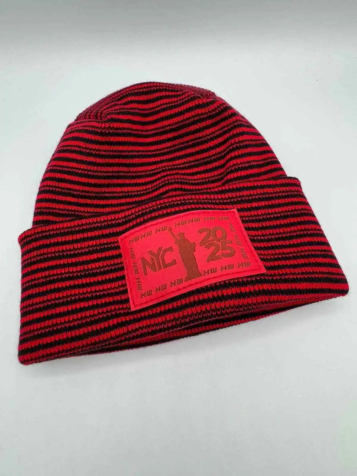 Cuffed beanie in red and black striped knit with front NYC 25 logo patch
