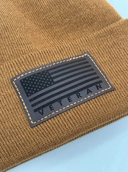Tan knit cuffed beanie with rectangular Veteran flag patch.