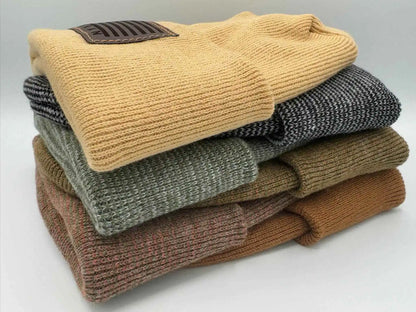 Stack of cuffed beanies in beige, gray, olive, and brown knit