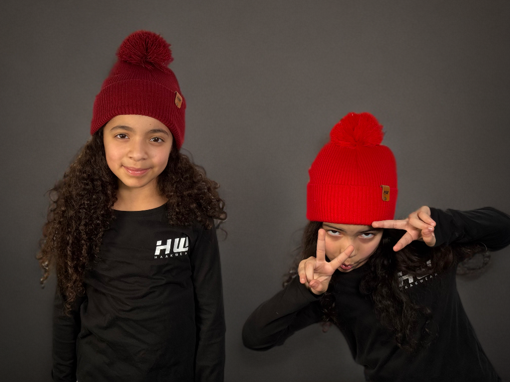 Two children wearing red beanies with pom-poms made in USA with free shipping