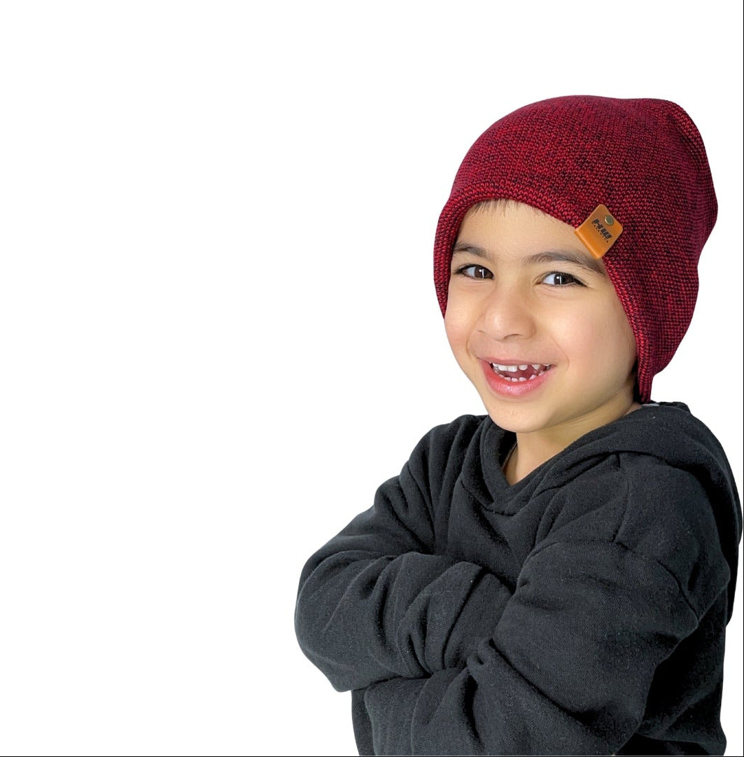 Child wearing a red beanie with a visible brand logo on a white background
