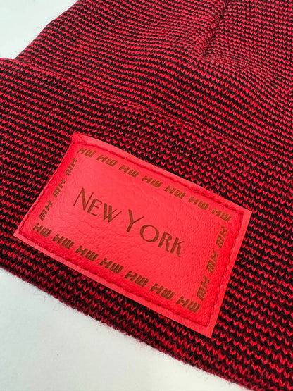 Red and dark knit beanie cuff with rectangular patch reading 'NEW YORK' 