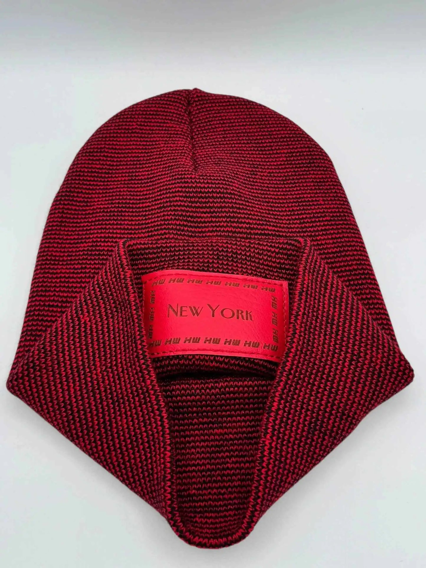 Red knit beanie with fold-over cuff and interior tag, rectangular 'NEW YORK' patch