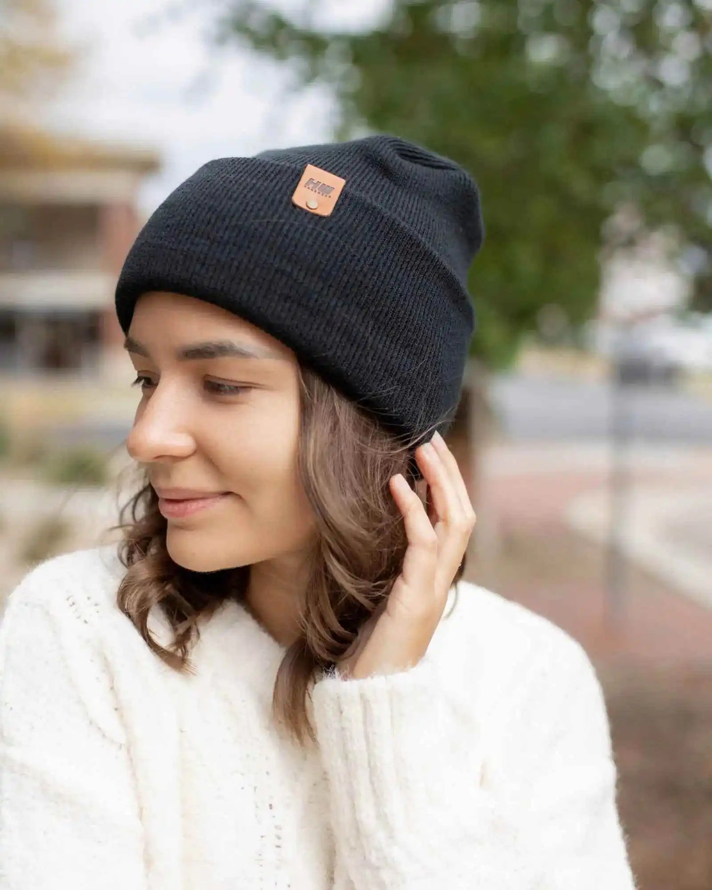 Charcoal black knit cuff beanie on person, angled side view