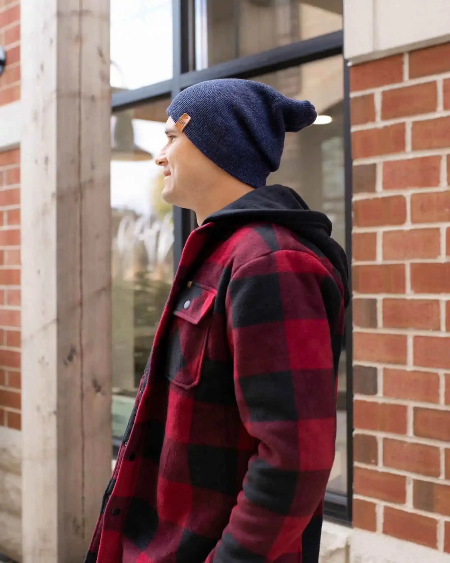 Denim blue knit cuffed beanie with folded brim, side view.