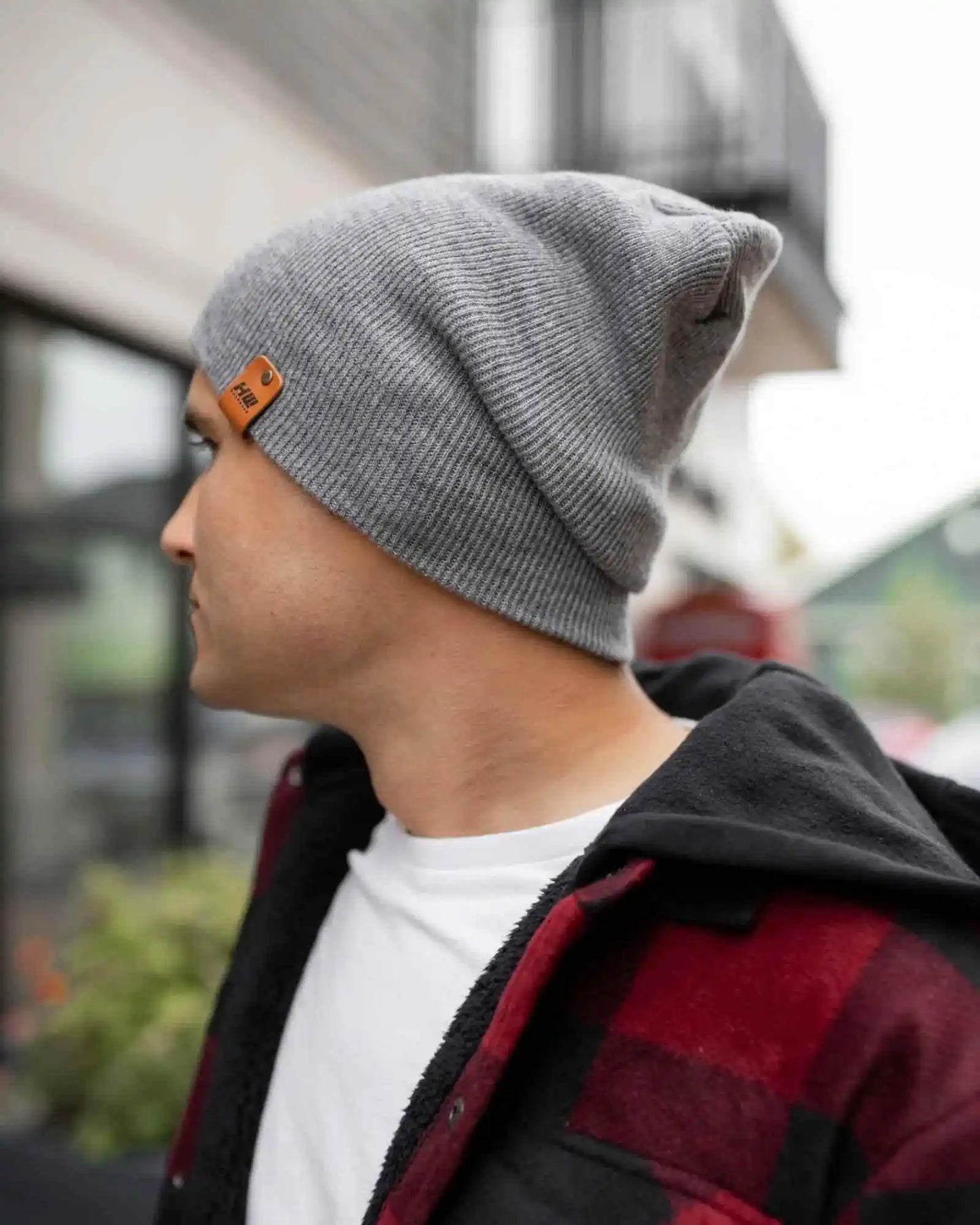 Gray beanie side view with logo patch on cuff and ribbed knit texture