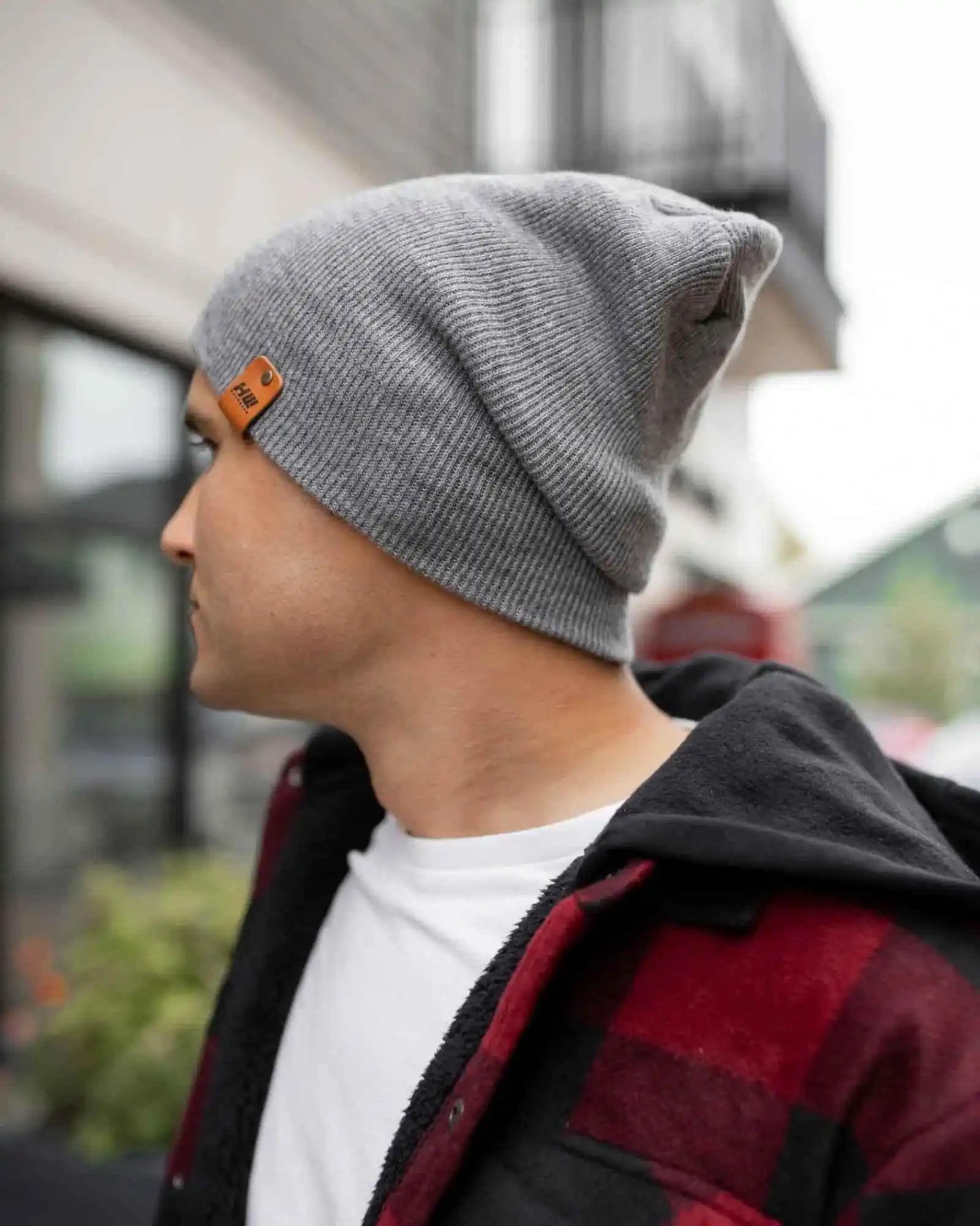 Gray beanie side view with logo patch on cuff and ribbed knit texture
