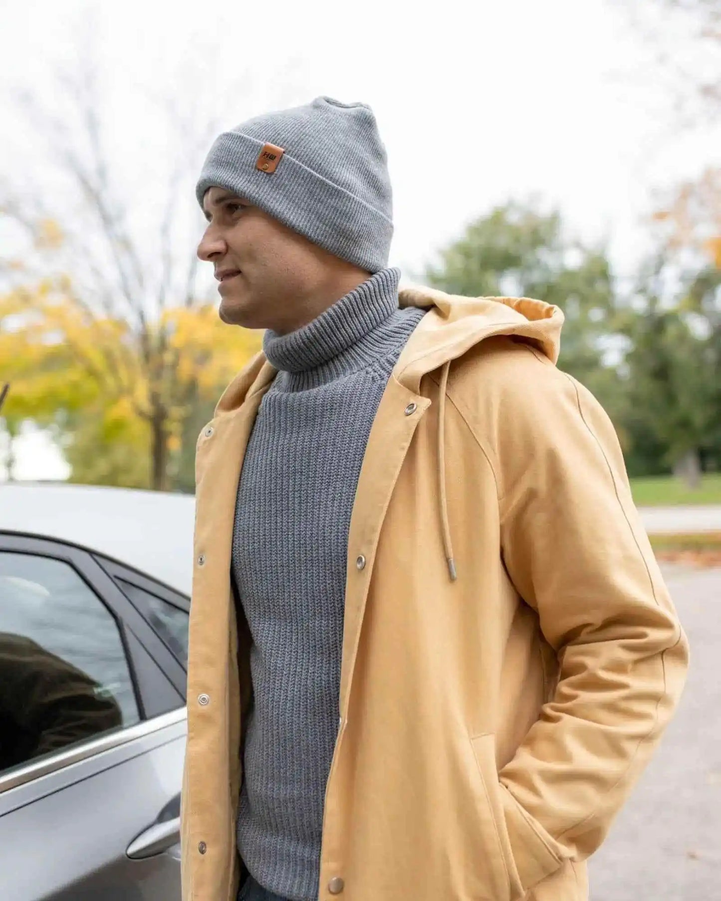 Gray cuffed beanie on a knit top, showing the logo patch at the front cuff