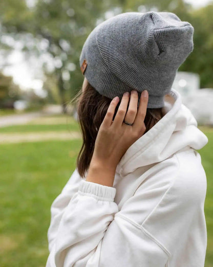 Gray cuffed beanie on head, back view with small square logo patch and soft knit