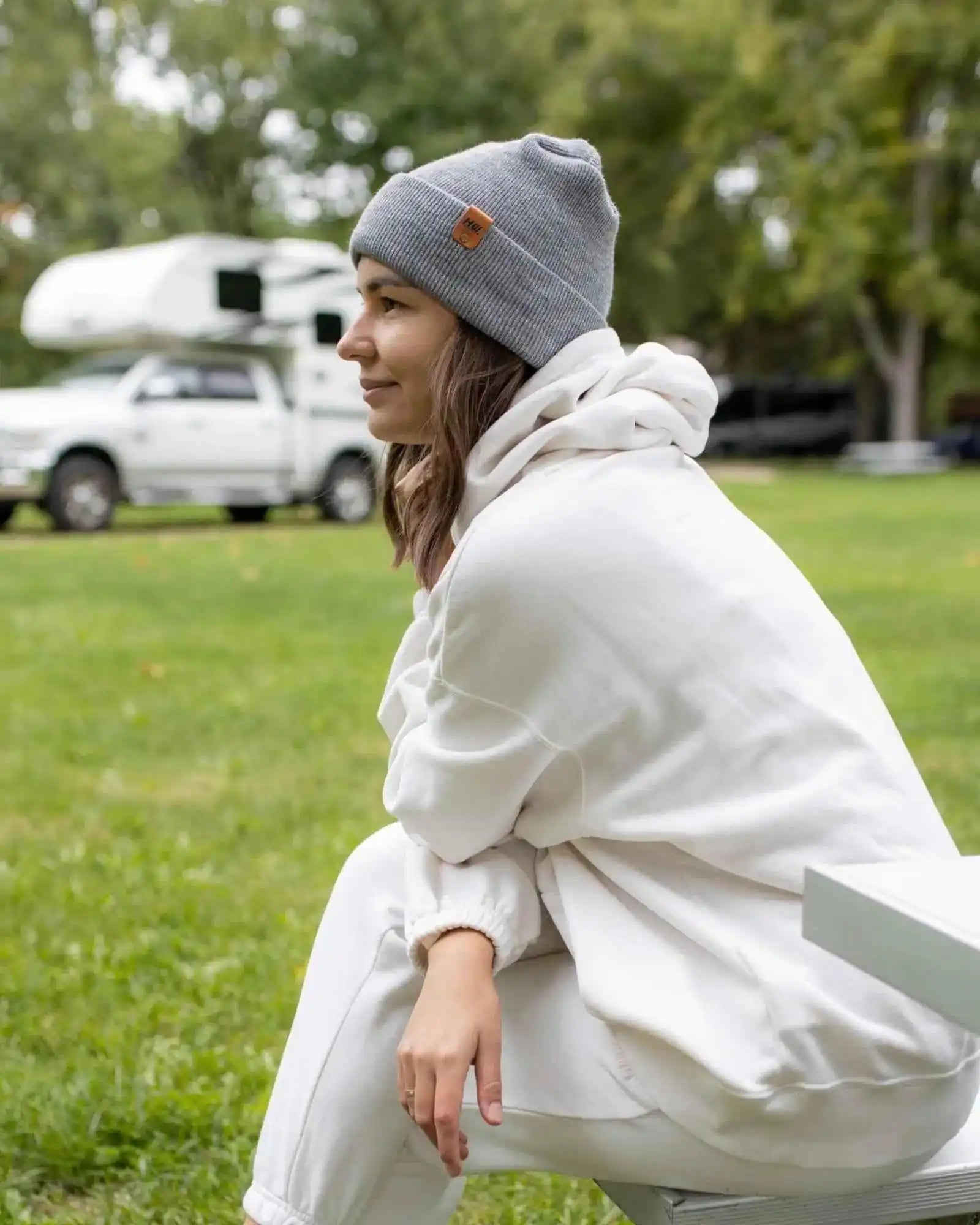Gray cuffed beanie with small square logo patch centered on the foldover top
