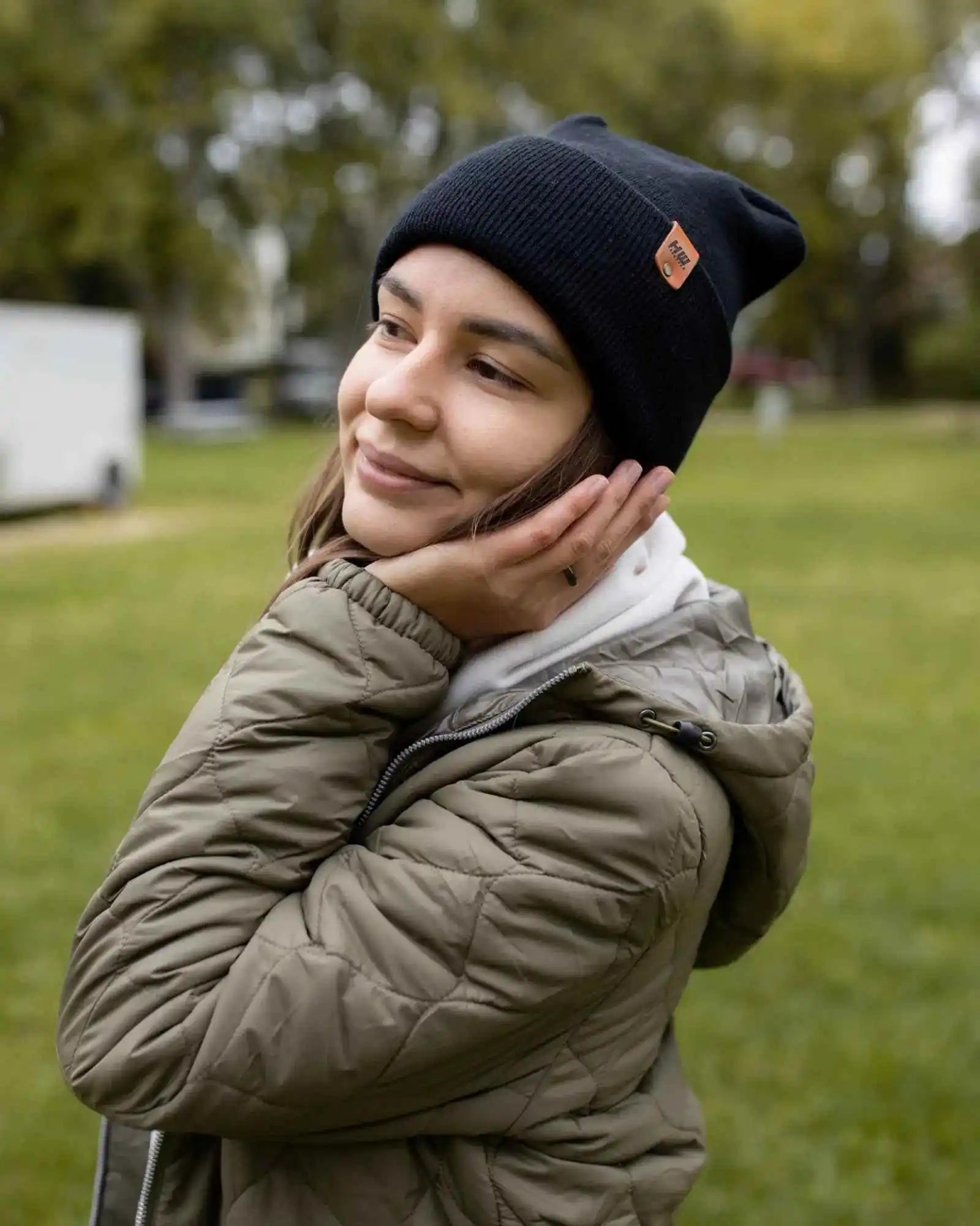 Midnight black cuffed beanie worn with outerwear, knit texture and logo patch
