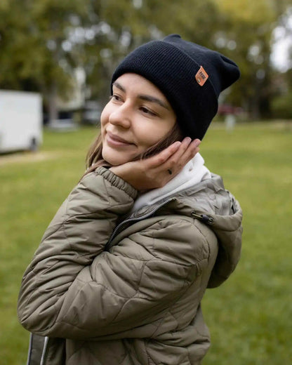 Midnight black cuffed beanie worn with outerwear, knit texture and logo patch