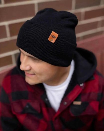 Midnight black cuffed beanie knit with orange logo patch on front.