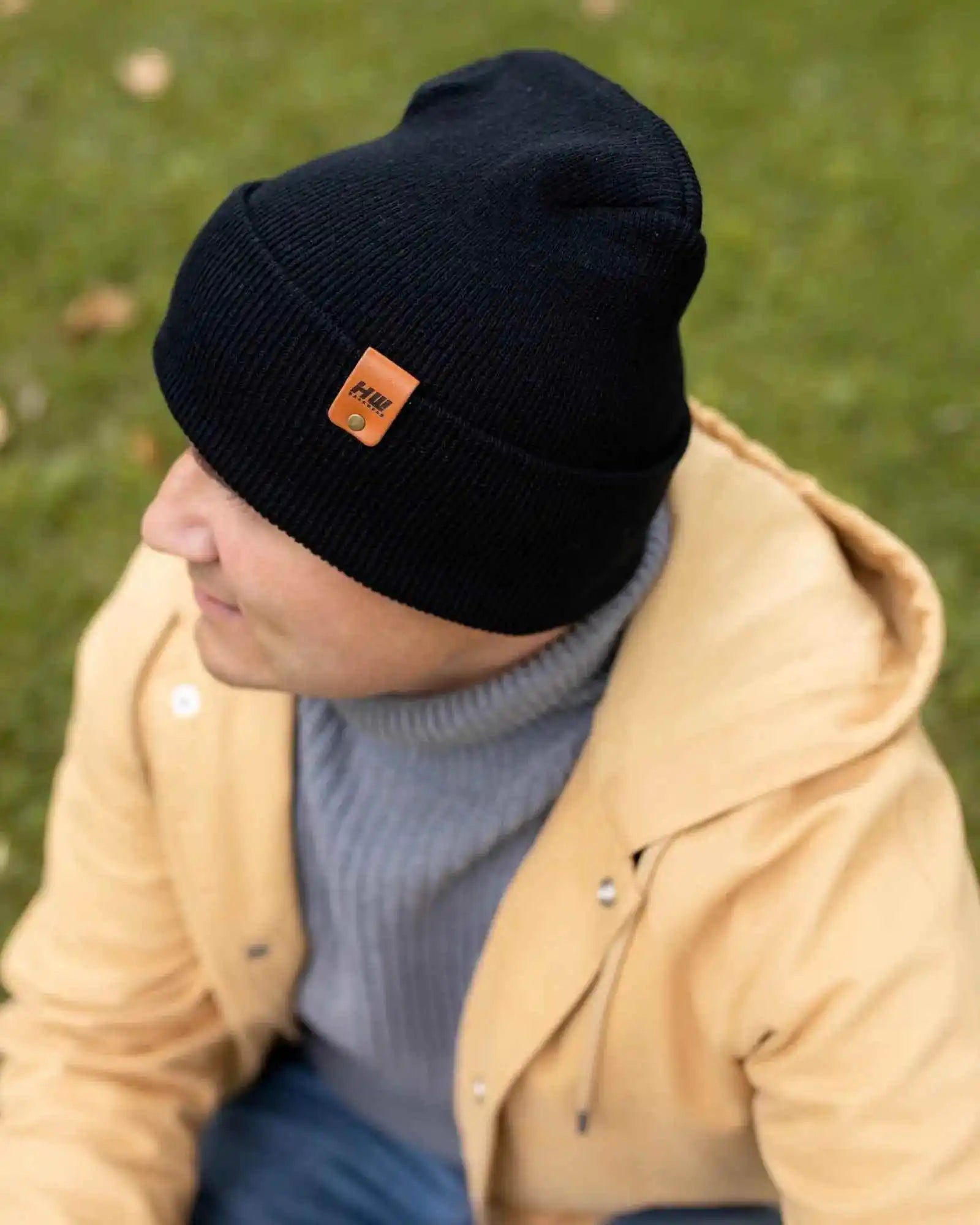 Midnight black cuffed beanie with knit texture and small brand patch