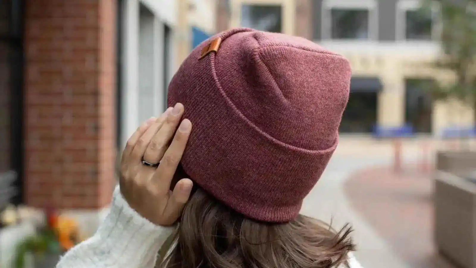 Rusty burgundy rib-knit beanie with folded cuff and small square logo patch