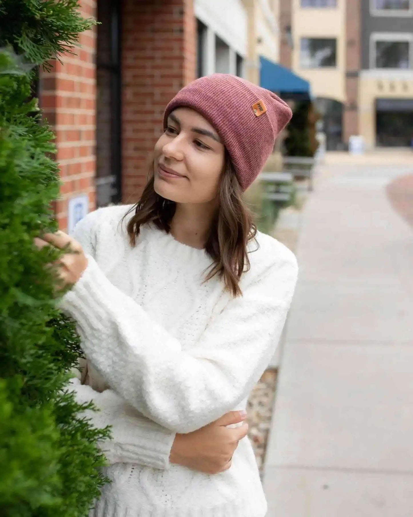 Rusty burgundy knit beanie with cuff and square logo patch on front
