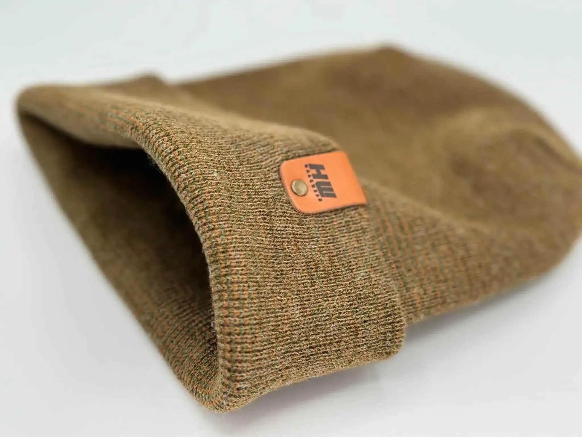 Brown knit beanie cuff with orange logo tag
