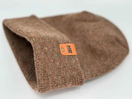 Brown knit beanie with fold-over cuff and tan leather logo patch