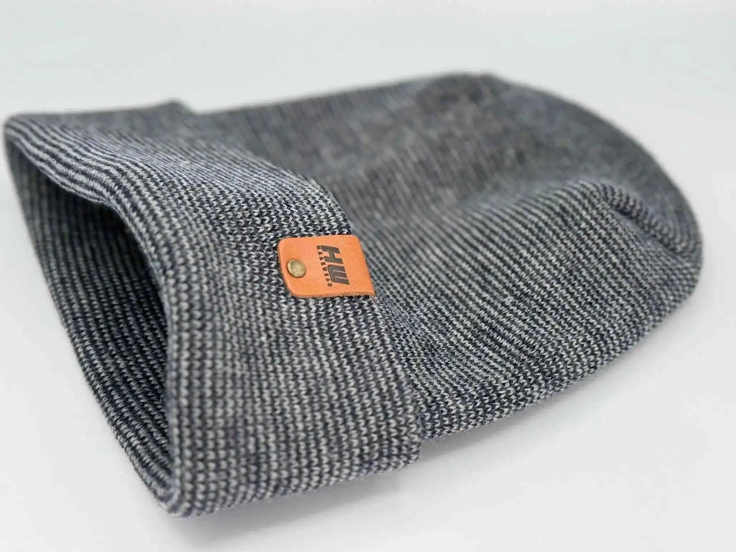 Gray cuffed beanie folded with orange logo patch on side