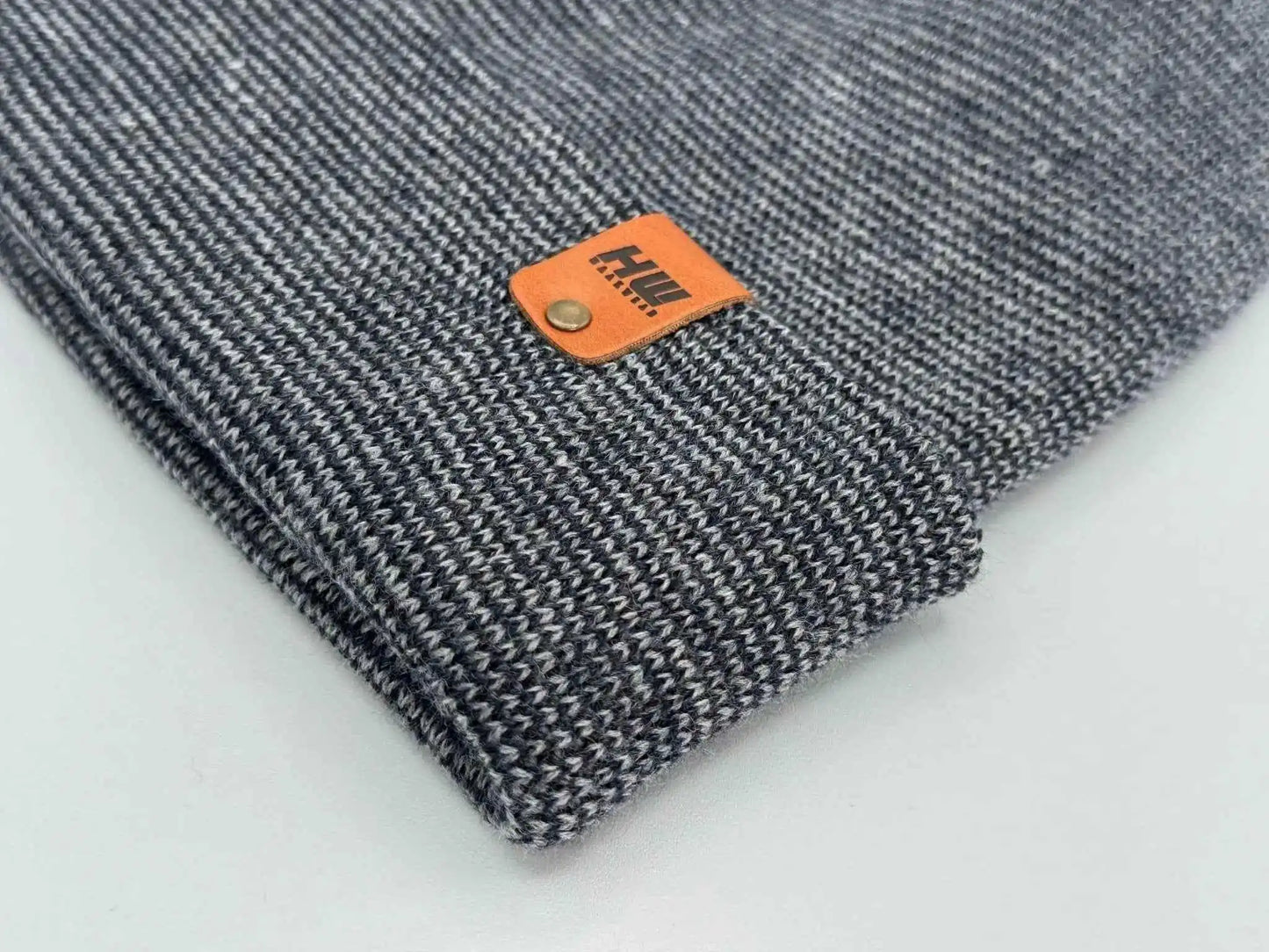 Gray knit beanie close-up with orange logo patch
