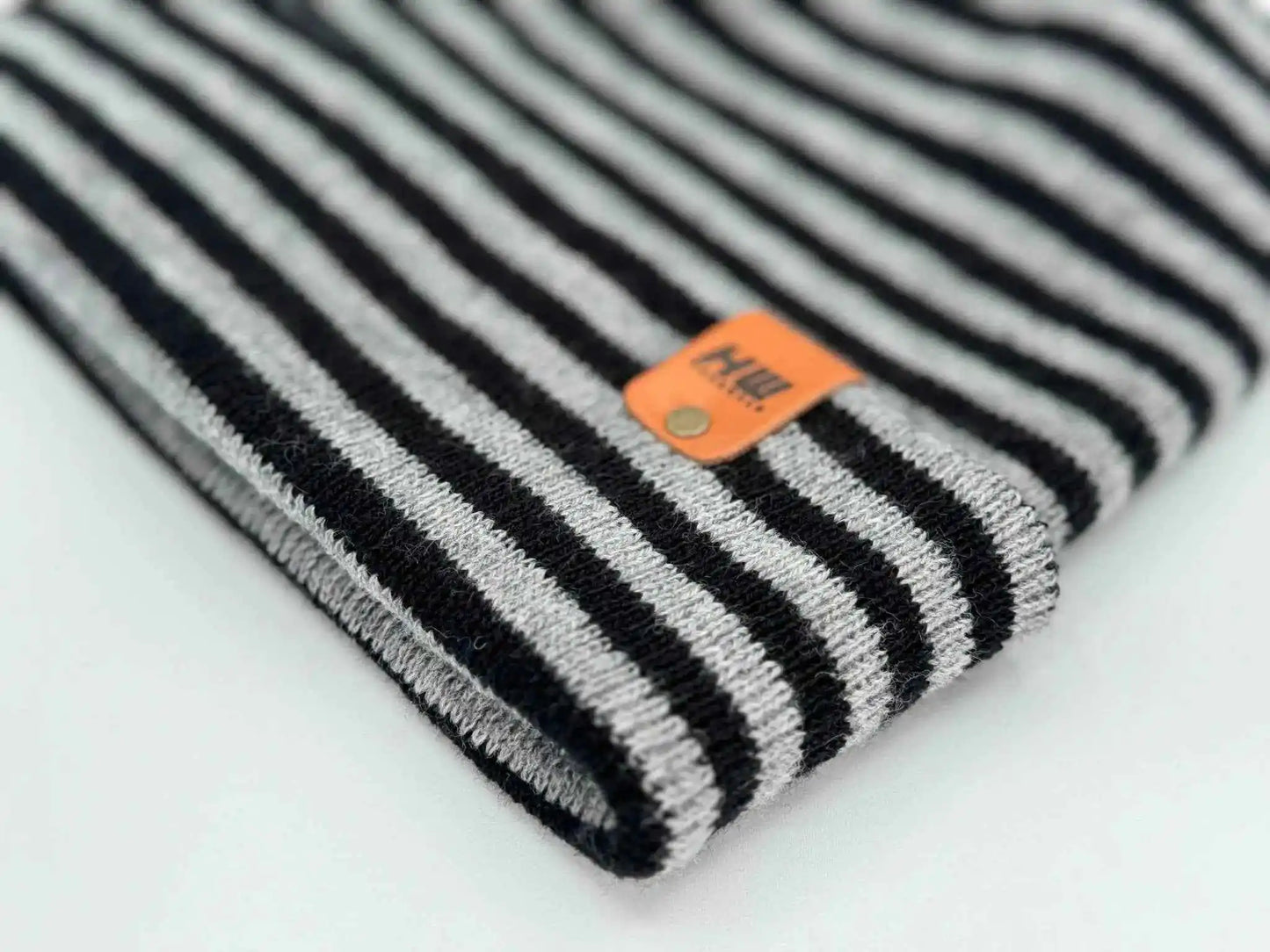 Folded striped knit beanie edge with orange logo patch, black and gray