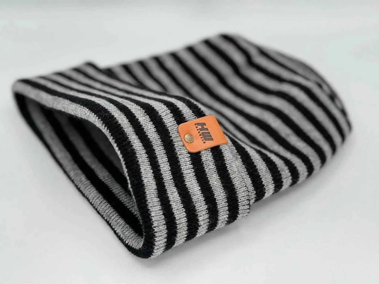 Striped cuffed beanie in black and gray with orange logo label