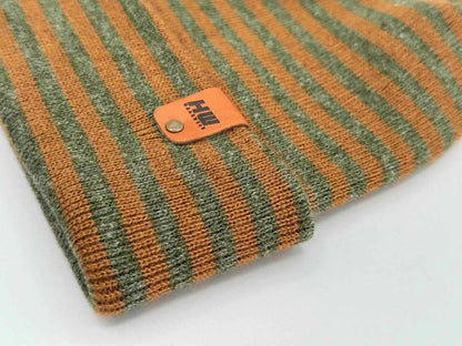 Brown and green striped cuffed beanie close-up of knit texture and leather patch