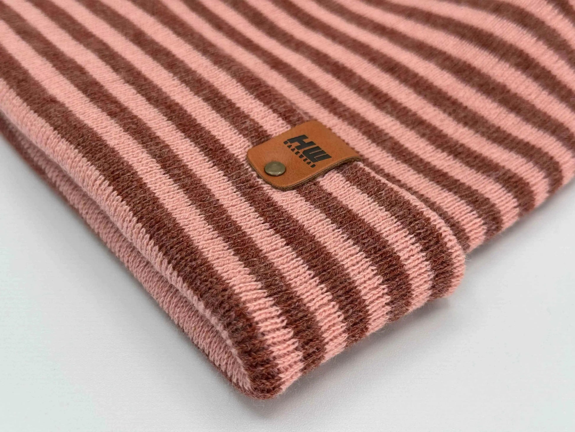 Striped knit beanie with folded cuff and leather-look brand patch, burgundy and pink