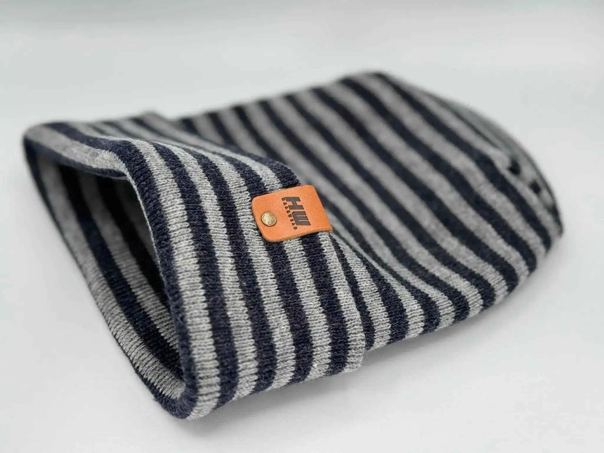 Striped cuffed beanie with folded brim and orange logo patch
