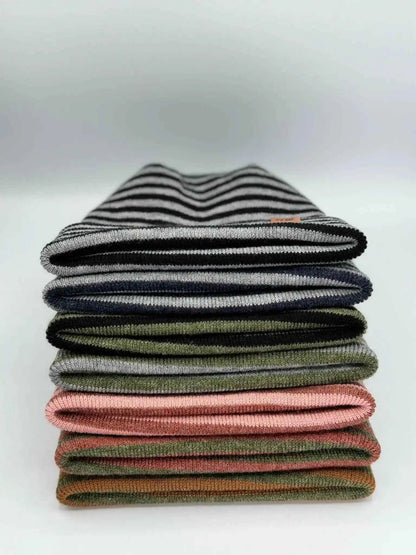 Stack of striped knit cuffed beanies in gray, green, and other colors