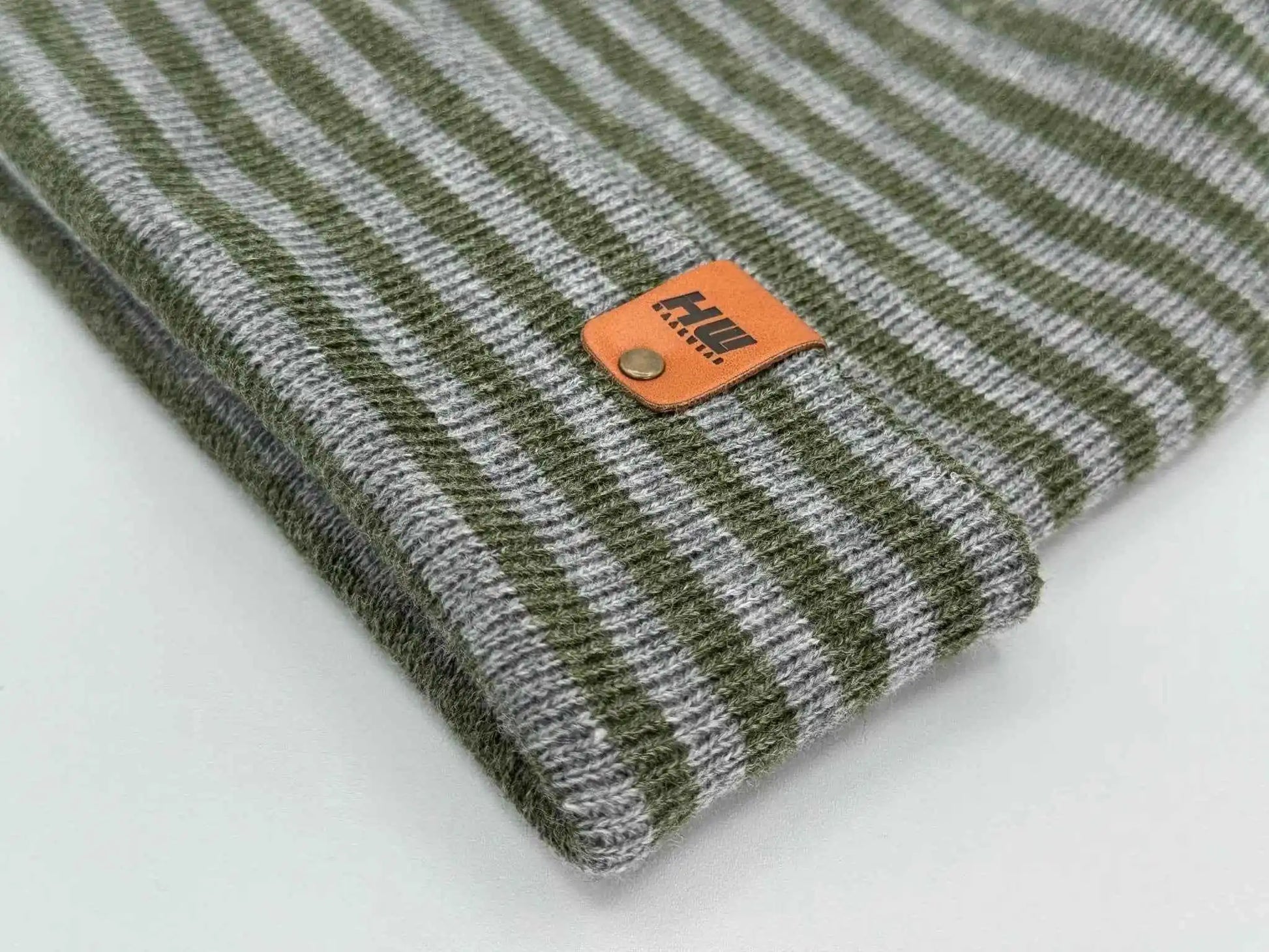 Gray and green striped beanie cuff with orange rectangular logo patch