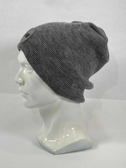 Gray knit beanie on mannequin, uncuffed with ribbed texture and side logo patch