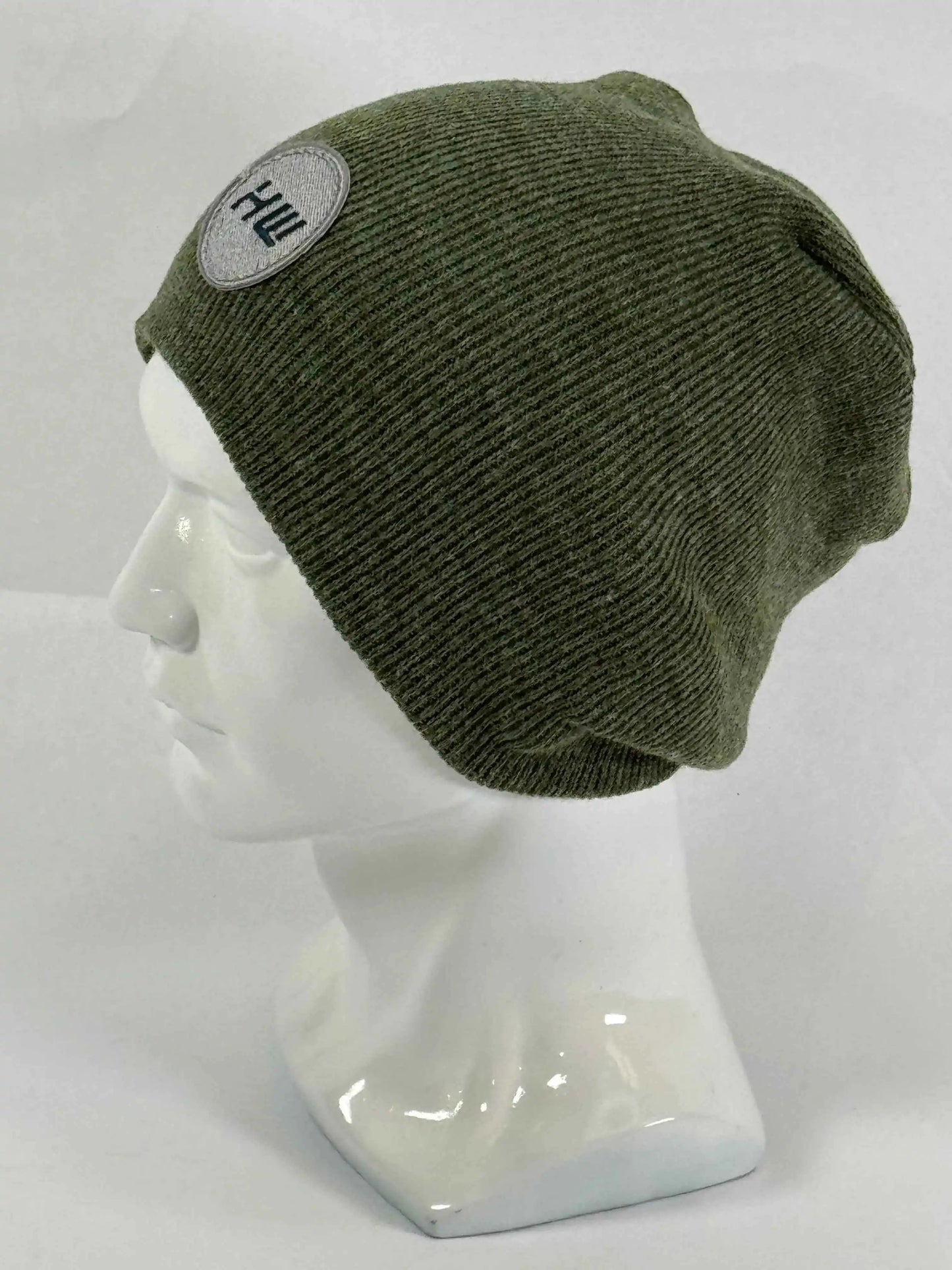Olive green knit beanie with un-cuffed ribbed edge and small HUI logo label.