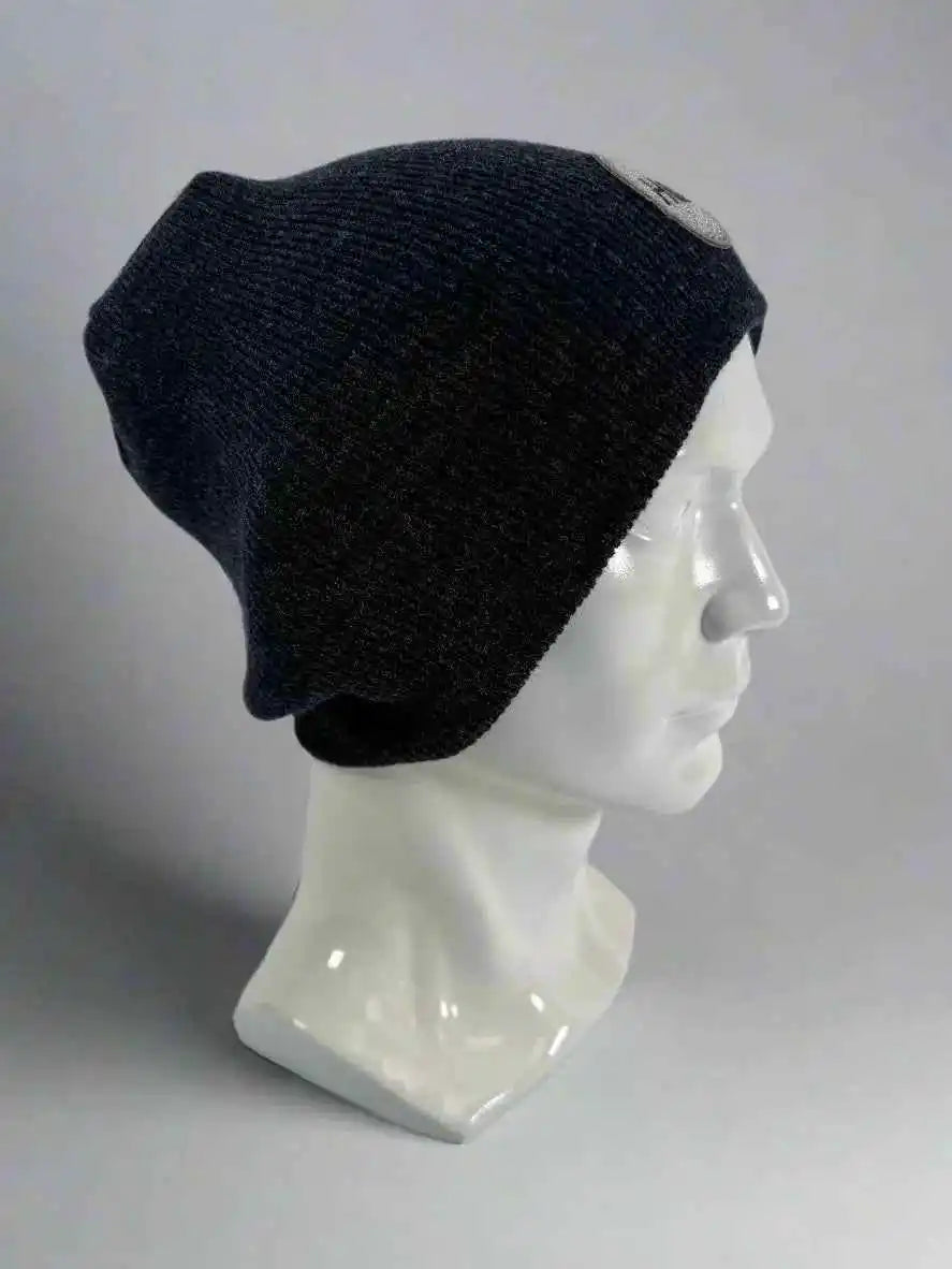 Black knit beanie with un-cuffed ribbed edge and small HUI logo label on side.