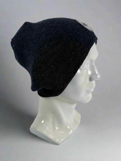 Black knit beanie with un-cuffed ribbed edge and small HUI logo label on side.