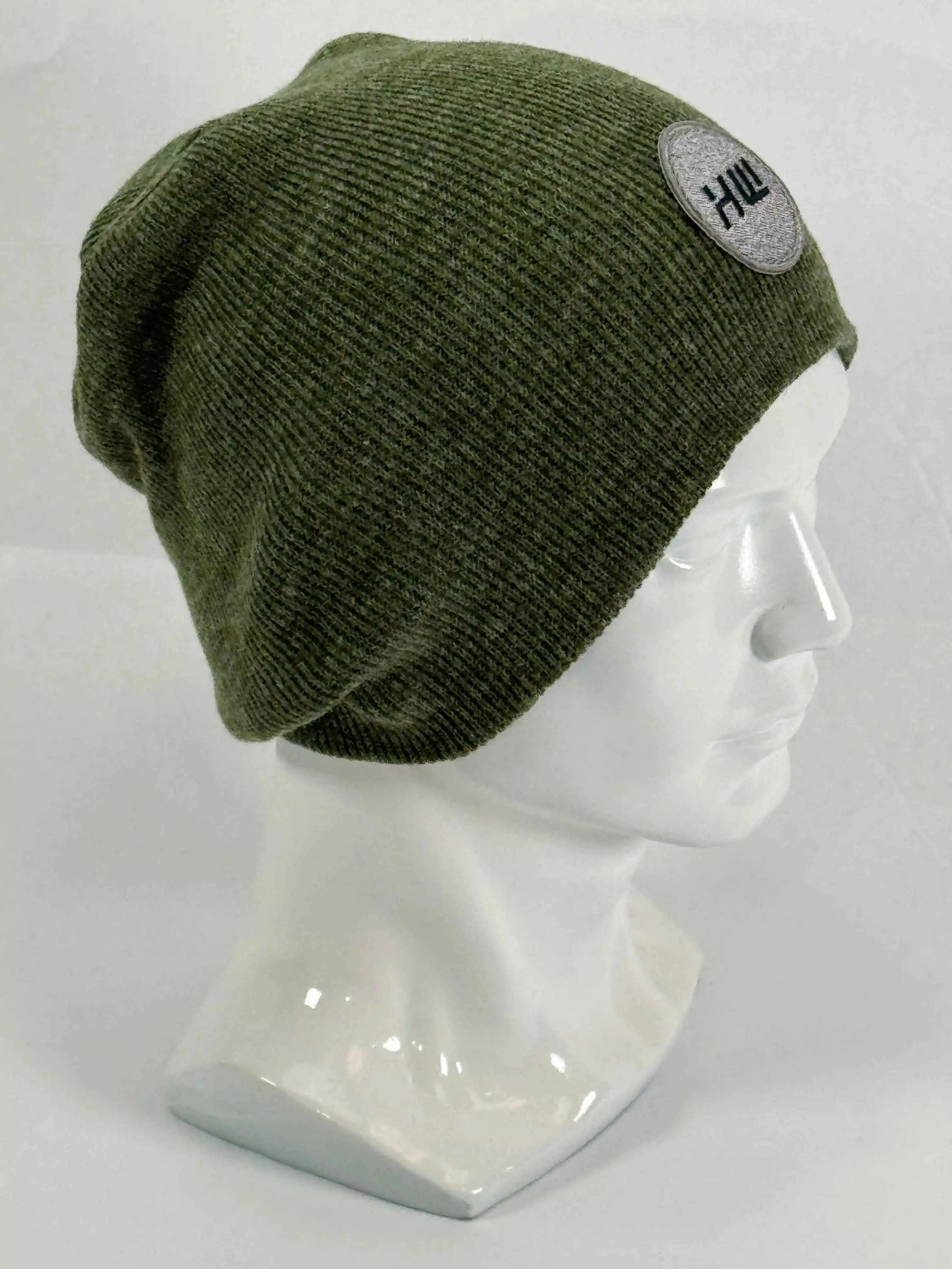 Olive green knit beanie with un-cuffed rolled edge and round HUI logo patch.